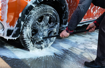 This image shows a man washing a car.