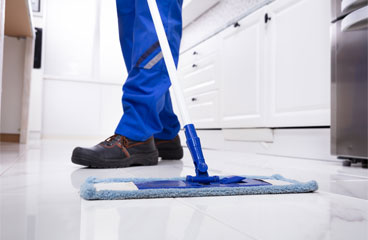 This image shows a man mopping the floor.