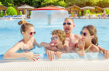 This image shows a family smiling while on a pool.